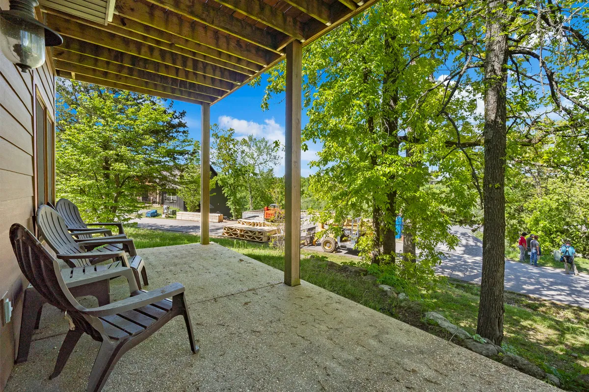 Wooden chairs are set out in an open, green area, inviting guests to relax and appreciate the lush natural beauty. The open space suggests opportunities for socializing or enjoying calm moments surrounded by greenery.