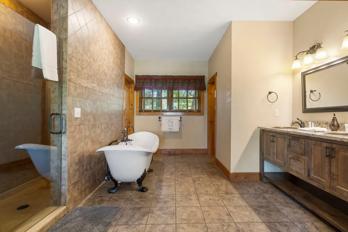 A luxurious bathroom with a freestanding bathtub, a vanity with a mirror, and a glass shower area. The space is uncluttered, with calming colors and plenty of natural light, emphasizing relaxation and comfort.