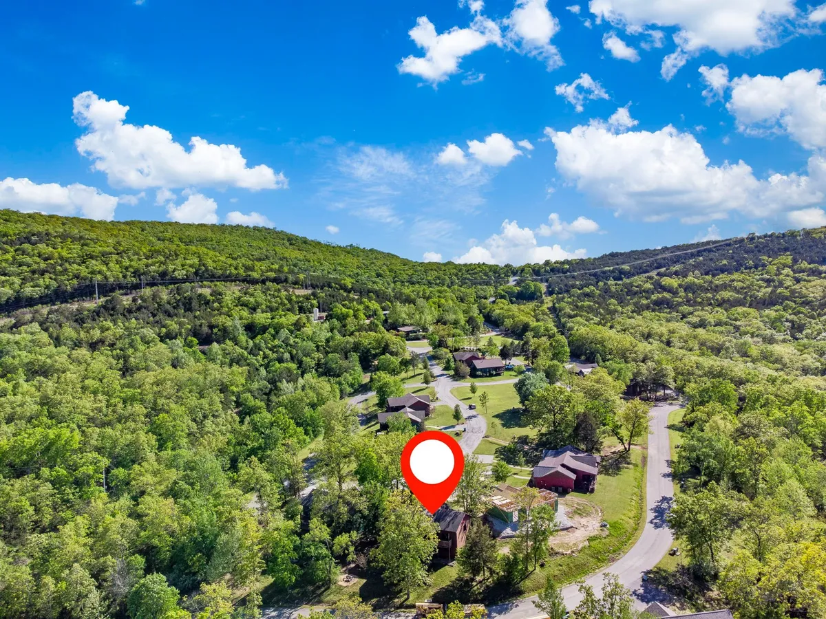 A wide, scenic view of lush green hills, winding roads, residential homes, and natural landscapes, depicting the picturesque environment surrounding the property and the outdoor adventures available nearby.